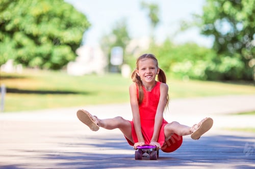 Preview: Adorable kid riding skateboard in summer park
