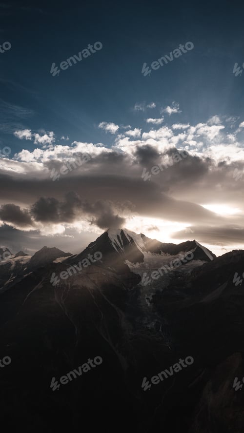 Preview: The Weisshorn illuminated by dramatic spring sunlight and clouds in the Swiss Alps.