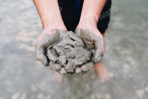 Preview: Man holds mud clay, close up.