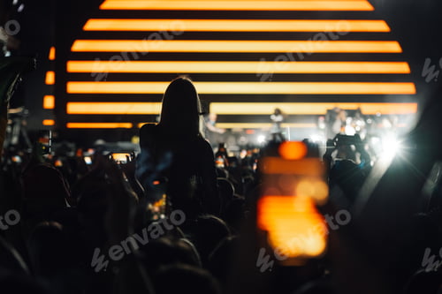 Preview: Crowd holding smartphones filming band performing live on stage