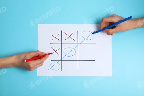 Preview: Women playing tic-tac-toe on color background, top view. Victory concept