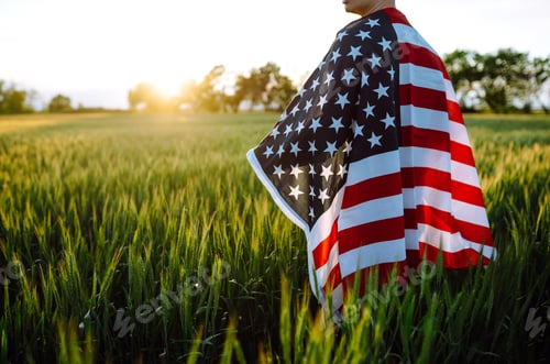 Preview: Man hold waving american USA flag. Patriot raise national american flag. Independence Day, 4th July.