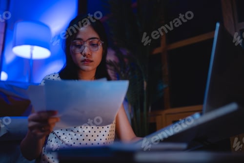 Preview: Late-night freelancer, Dedicated Asian woman working overtime on laptop computer, meeting deadlines