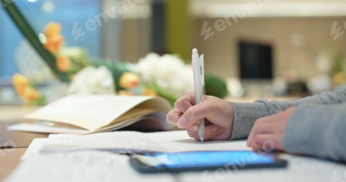 Preview: Woman write on the note for studying with cellphone