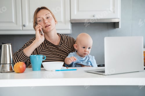 Preview: Working Mother with Infant Using Laptop at Home