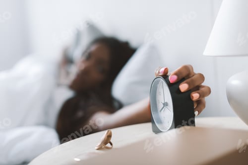 Preview: close-up shot of african american woman turning alarm clock off
