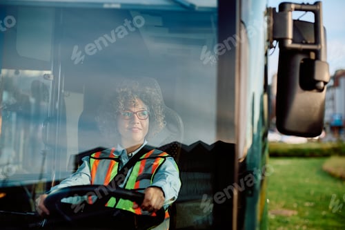 Preview: Happy female bus driver looking at side view mirror while parking in reverse at the station.