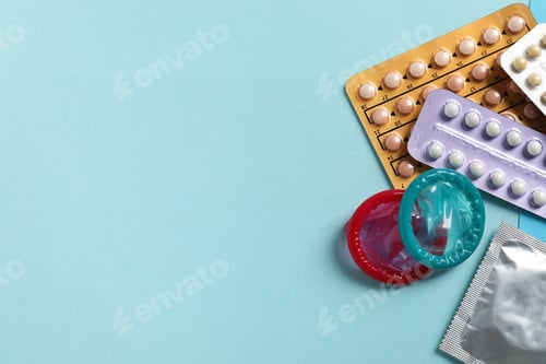 Preview: Blisters of contraceptive pills and condoms on light blue background, flat lay. Space for text
