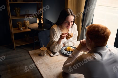 Preview: Pleasant young couple is resting in a cafe by window