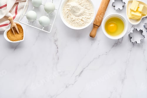 Preview: Baking background with flour, eggs, kitchen tools, utensils and cookie molds on white marble table.