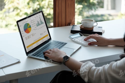 Preview: Businesswoman using calculator and laptop for calaulating finance, tax, accounting, statistics and