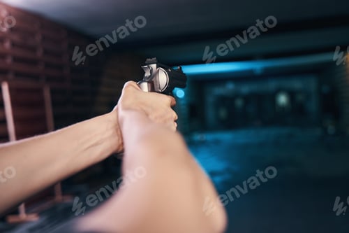Preview: Adult man aiming his pistol at a target