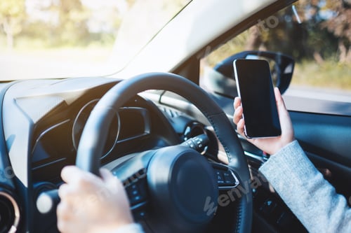 Preview: Hands Holding Phone While Driving Car in Daytime
