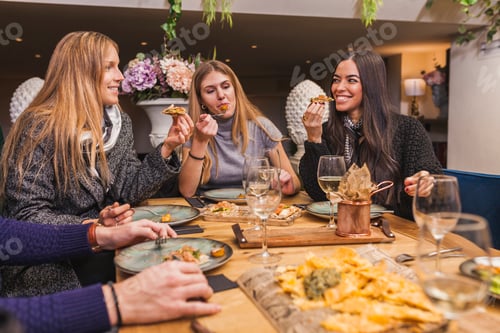Preview: Group of friends eating at a dinner party at restaurant