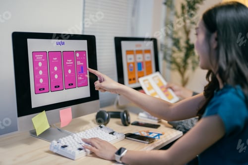 Preview: Two asian ui/ux designers are discussing the design of a mobile application interface displayed on a