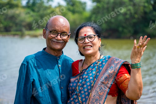 Preview: Happy Indian senior couple near river