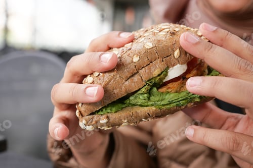 Preview: women eating organic vegan burger.