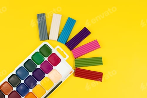 Visualização: tintas aquarela e plastilina multicolorida sobre fundo amarelo