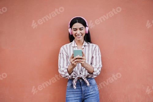 Preview: Young latin woman using mobile phone in the city