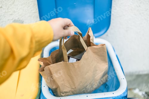 Preview: Full size of caucasian woman sorting garbage, throwing a used paper bag