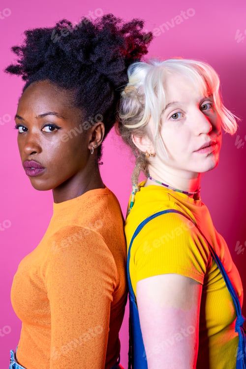 Preview: Portrait of young black and caucasian woman looking camera