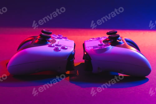 Preview: Composite of video game pads and copy space on neon background