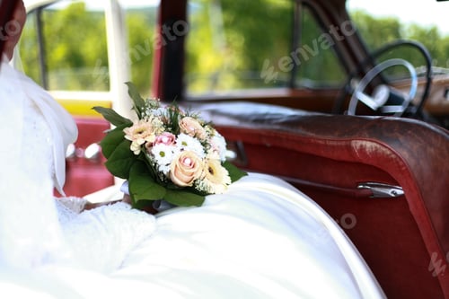 Preview: Bride in vintage car with bridal bouquet