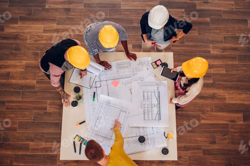 Preview: High angle shot of a multiracial team of architects having a meeting
