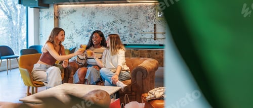 Preview: Three women friends relaxing together and toasting with healthy juice drinks