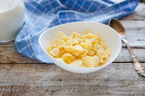 Preview: Bowl of sugar-coated corn flakes, milk, coffee and spoon wooden background