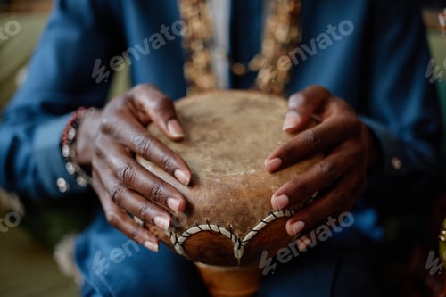Preview: Black Man Playing Traditional Drum during Kwanzaa Celebration Indoors