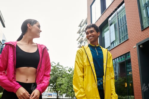 Preview: Young athletes taking a casual stroll outdoors in bright athletic gear on a cloudy day