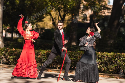 Preview: Three hispanic people dancing flamenco next to the gardens of a square