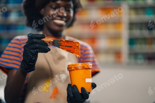Preview: Interracial printing shop worker mixing paint for silk screen printing