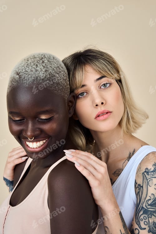 Preview: Two gen z African and European girls on beige background, vertical portrait.