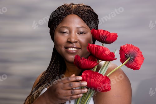Preview: Portrait of black woman with glossy radiant skin and carnations flowers in hand