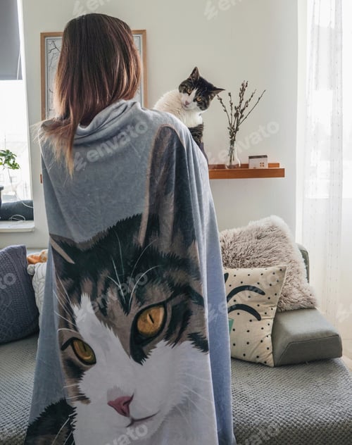 Preview: Woman bundled up in a blanket holding her cat.