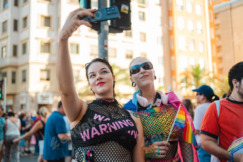 Preview: Two women taking a selfie at pride parade with rainbow flag