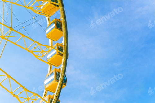 Preview: Yellow ferries wheel on blue sky background.