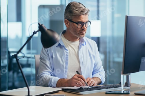 Preview: Successful senior boss with glasses, working on computer, businessman in shirt