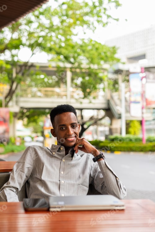 Preview: Portrait of handsome young black man outdoors in city