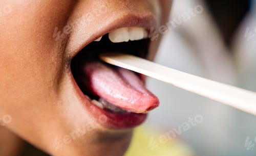 Preview: Pediatrician examining little girl's throat with tongue depressor