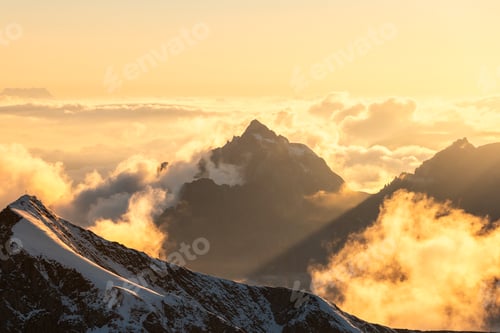 Preview: Sunset Light Beams over Cloudy Peaks