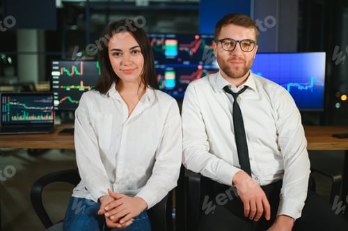 Preview: Team of stockbrokers are having a conversation in a dark office with display screens