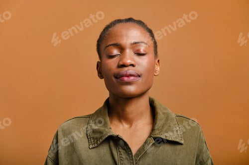 Preview: close up portrait of Young black woman meditating eyes closed studio