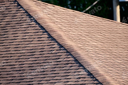 Preview: Closeup of house roof top covered with asphalt or bitumen shingles. Waterproofing of new building