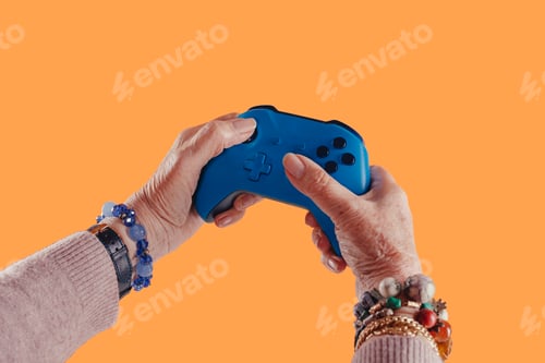 Preview: Hands of elderly grandmother holding controller playing video game