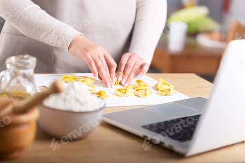 Preview: Woman preparing ravioli watching virtual culinary master class