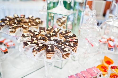 Preview: Different sweets and cupcakes at catering wedding reception table.