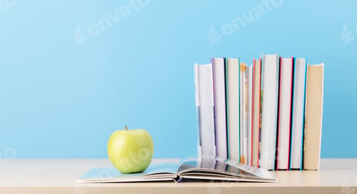 Preview: Stack of books on desk and apple